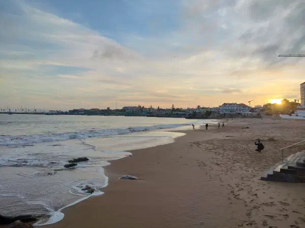 Cascais beach at sunset with the coastal town beyond